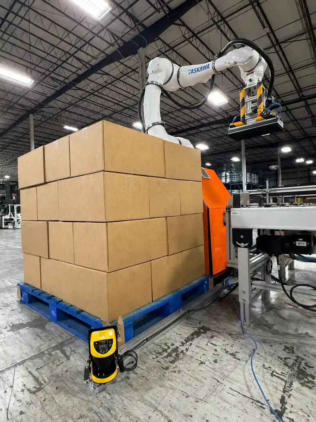 Mobile robotic palletizer beside a completed pallet of cases